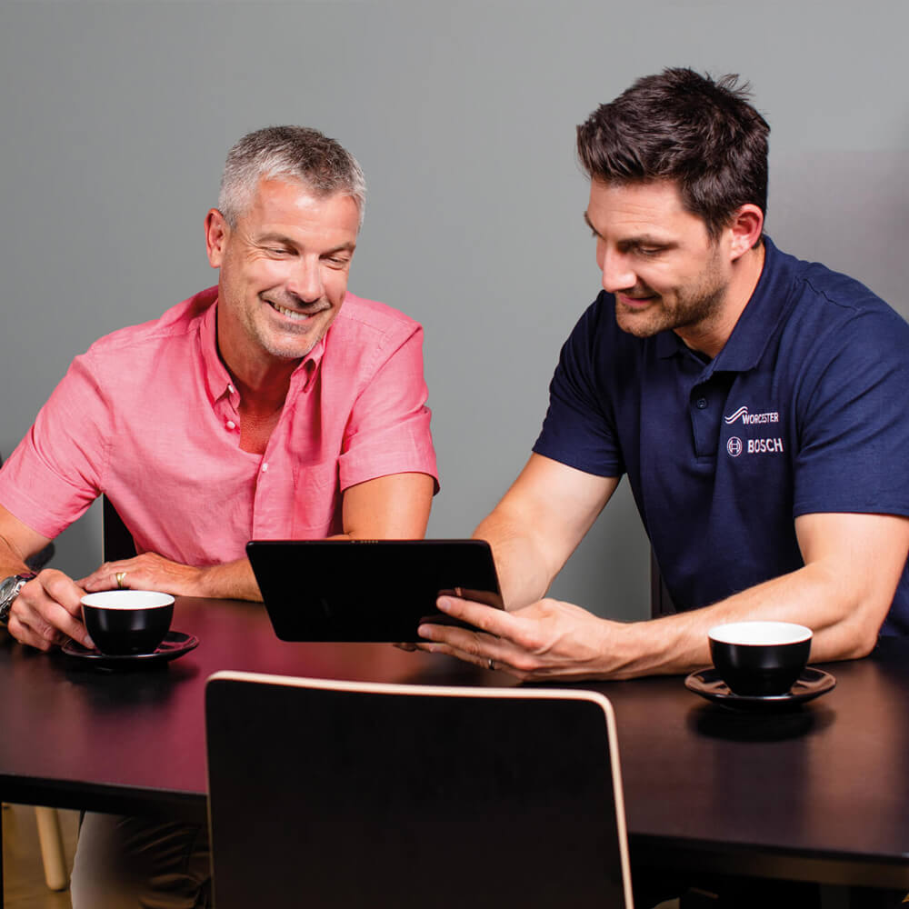engineer sitting with client and looking at ipad